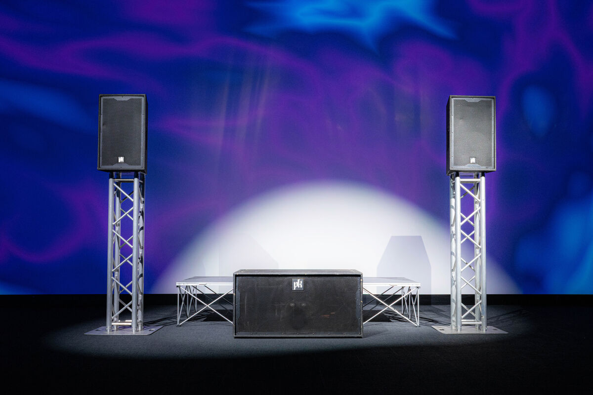 A single CX800 subwoofer between two CX215 tops on truss totems.