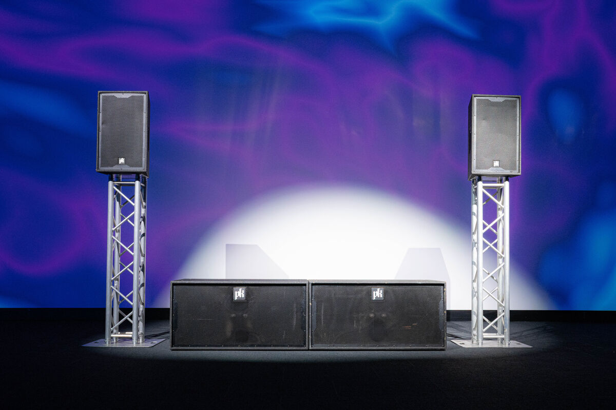 Two CX800 subwoofers side by side between two CX215 tops on truss totems.